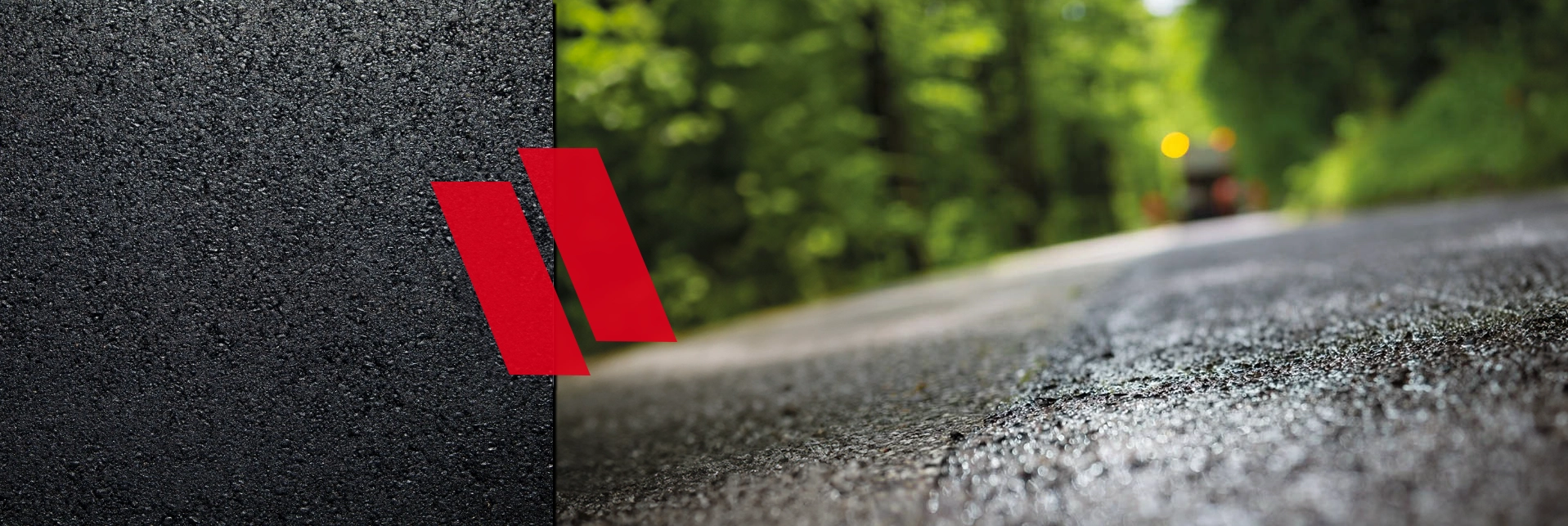 Nahaufnahme eines Straßenbelags mit Vialit-Logo, umgeben von grüner Vegetation und einem verschwommenen Hintergrund.